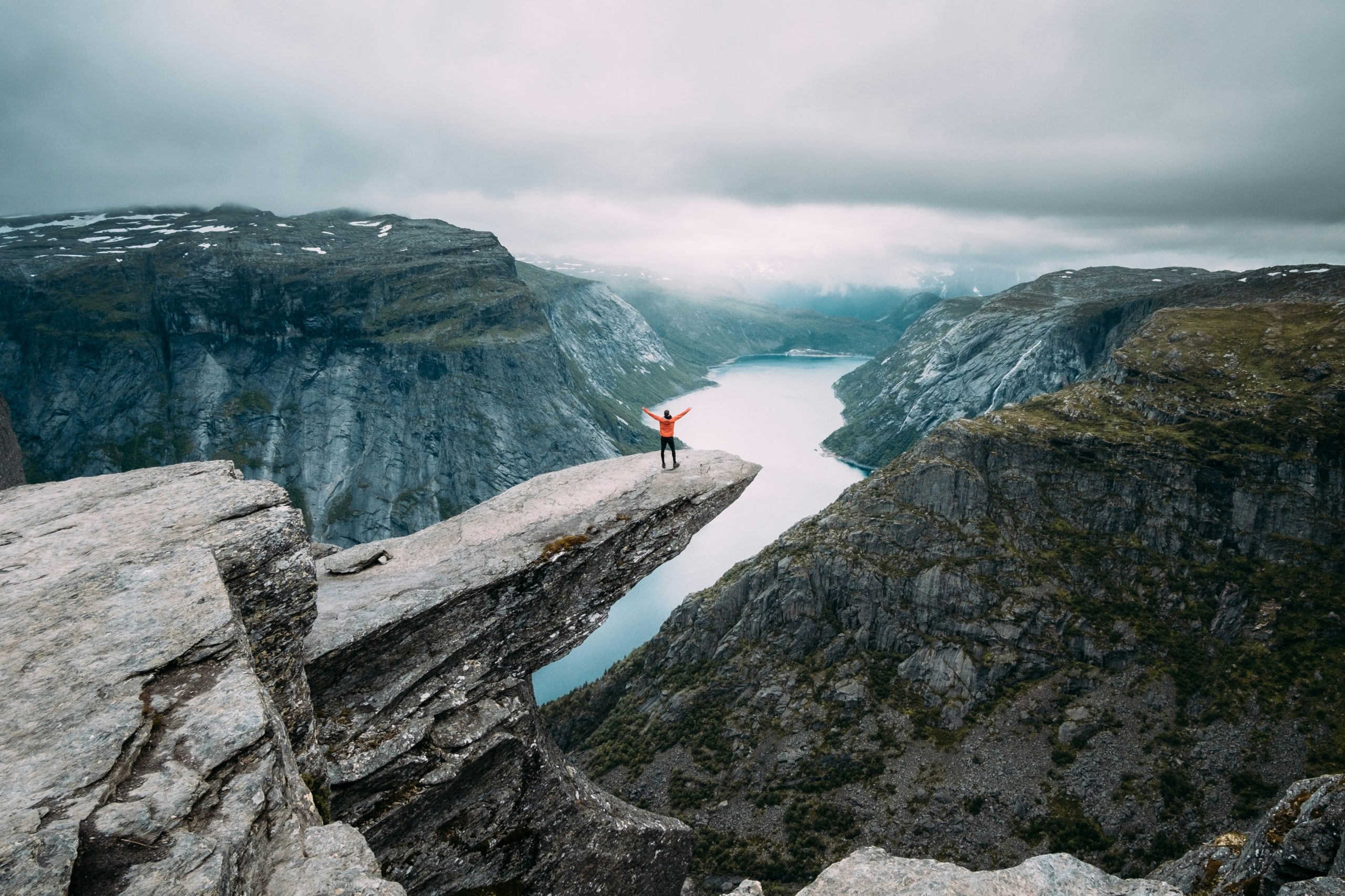 a person standing on a cliff edge with arms outstretched